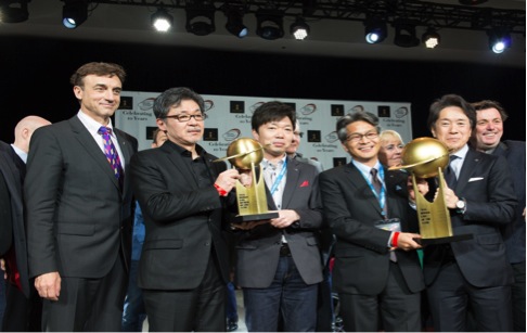 Mazda Motor North American Operations team holding up trophies after winning both 2016 World Car of the Year and Car Design of the Year awards