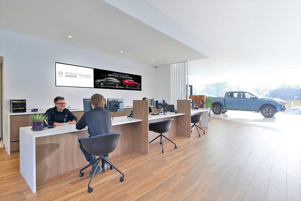 A Mazda Sales Consultant engaging with a customer in the spacious and luxurious interior of the new Bayswater Mazda showroom